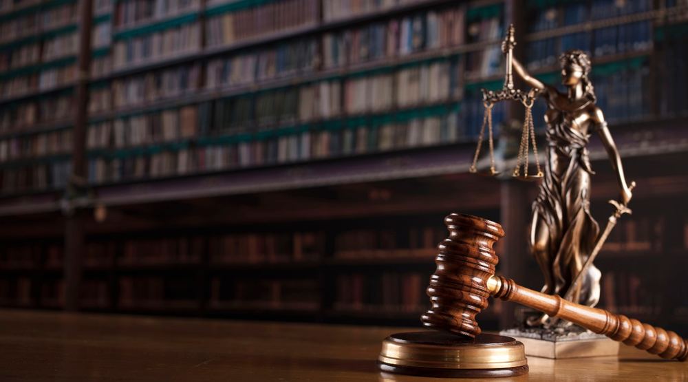 Gavel and statue of Justice in a law library